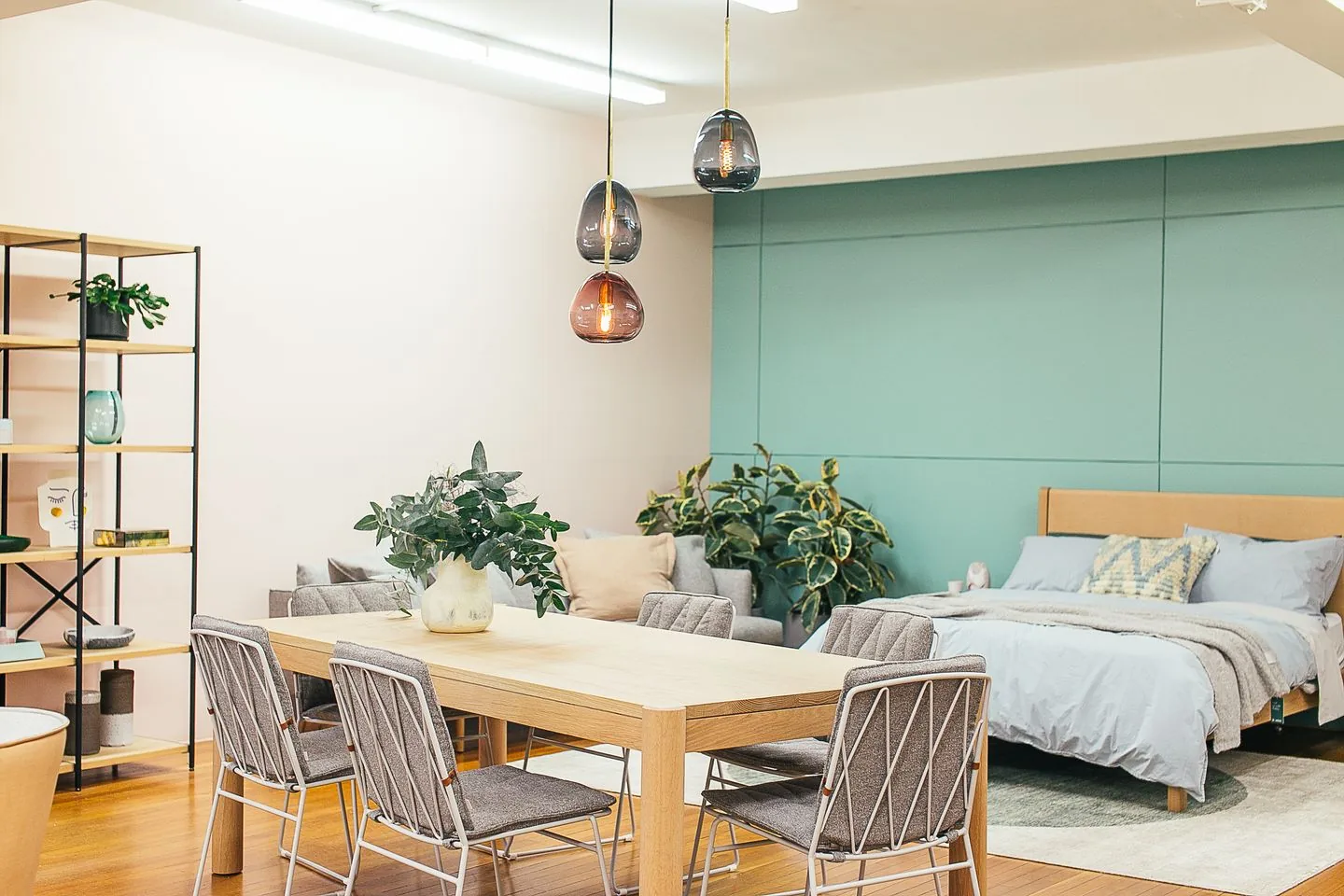 Dining table beside seating and sleeping areas in a studio