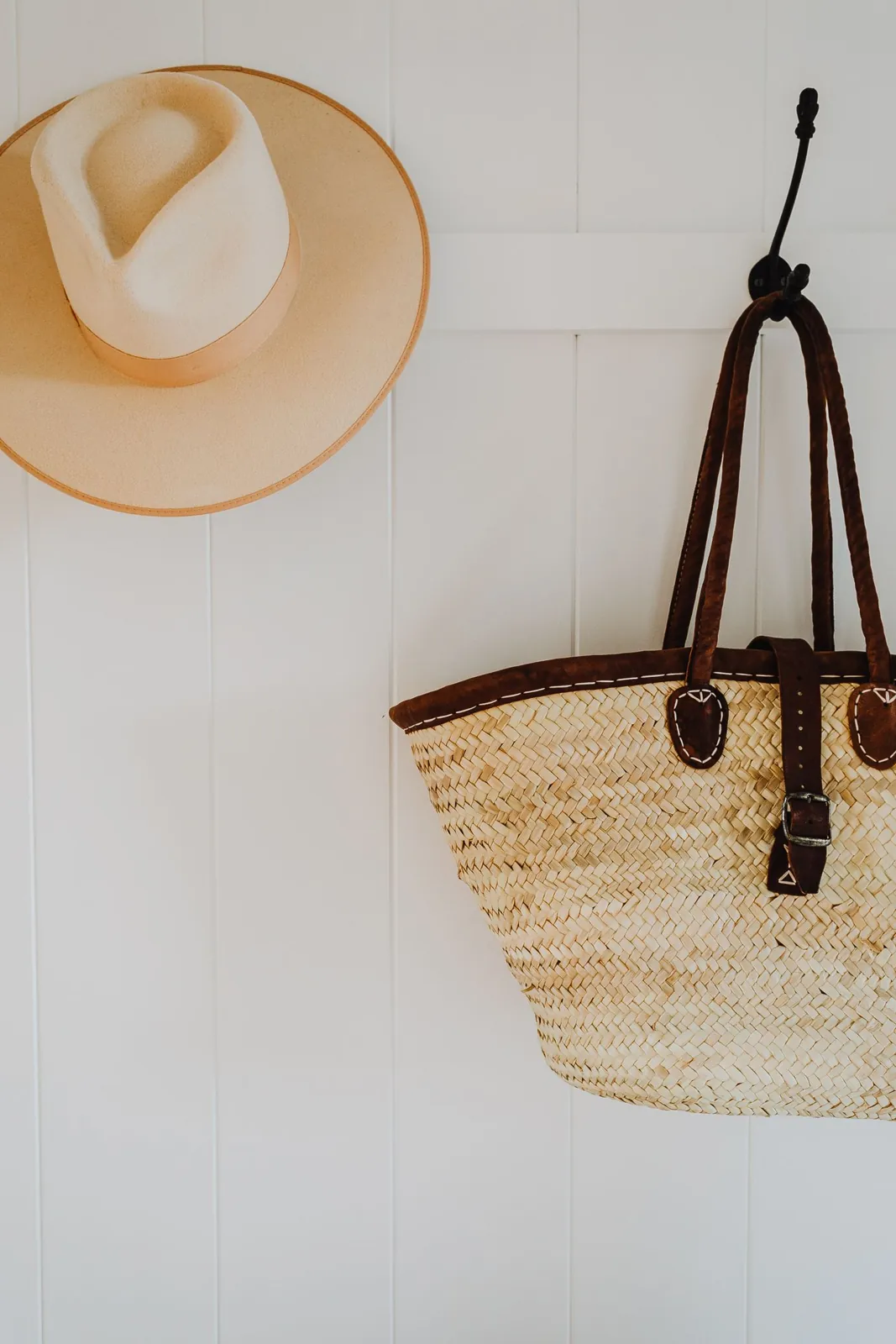 Hat and woven bag hanging from entrance hooks
