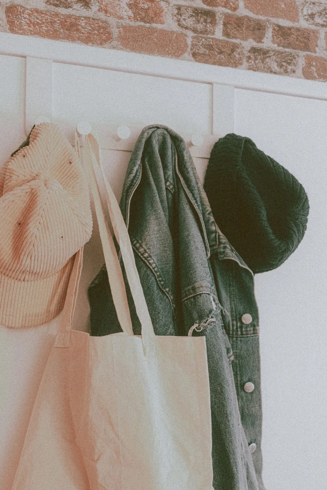 Coat, scarf, hat and bag hanging on wall hooks