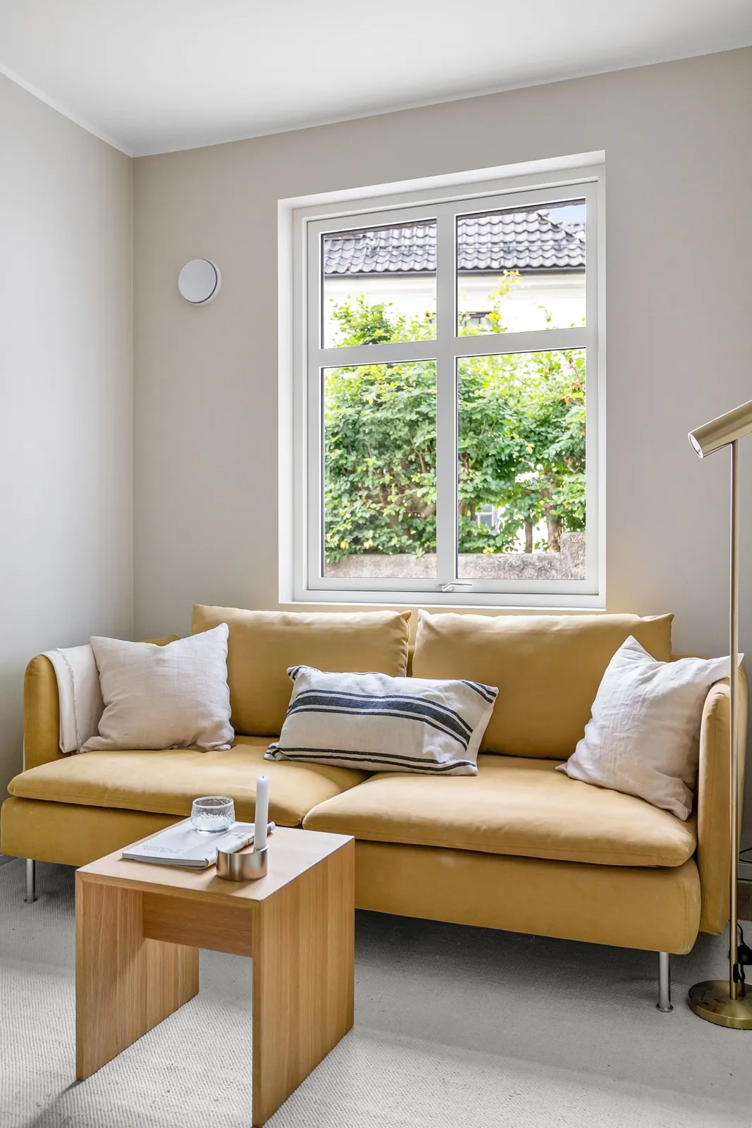 Yellow sofa adding colour to a pale living room