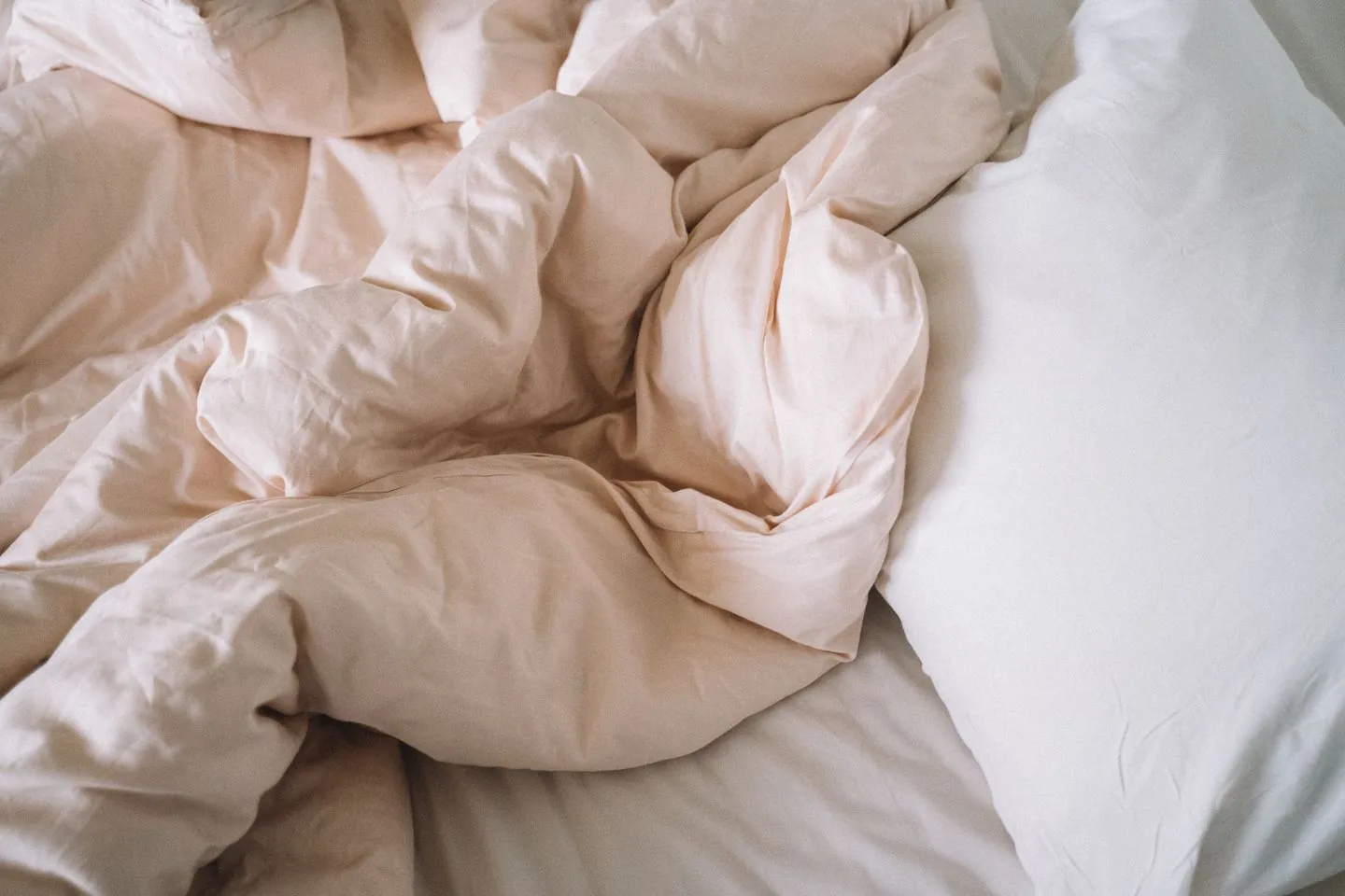 Soft bedding and a rumpled duvet on a bed