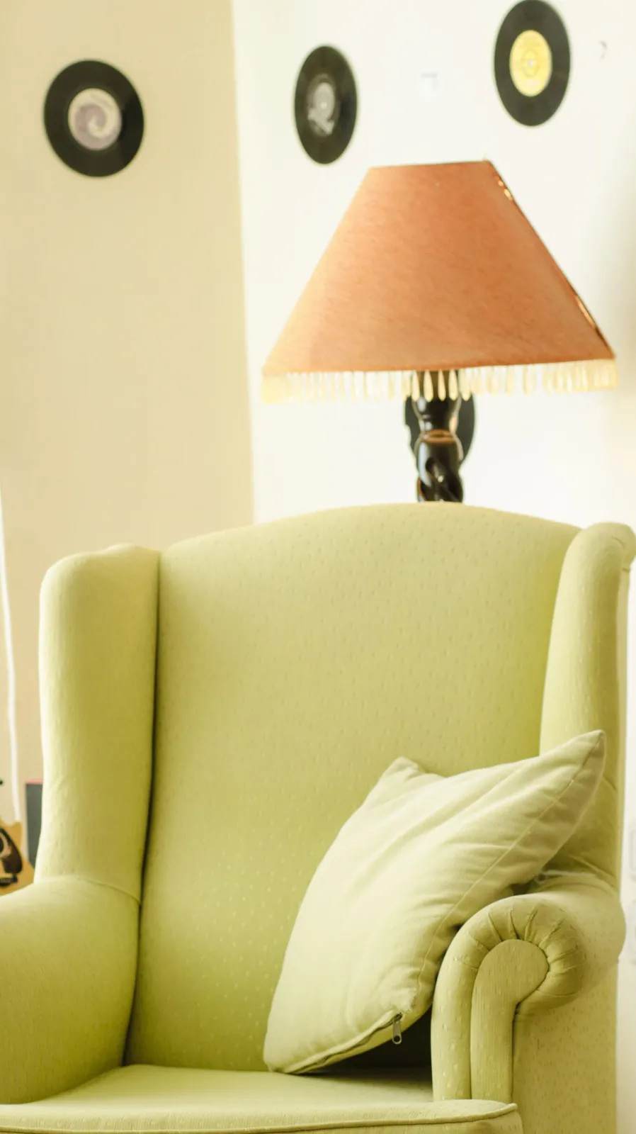 Green armchair beside a softly glowing table lamp