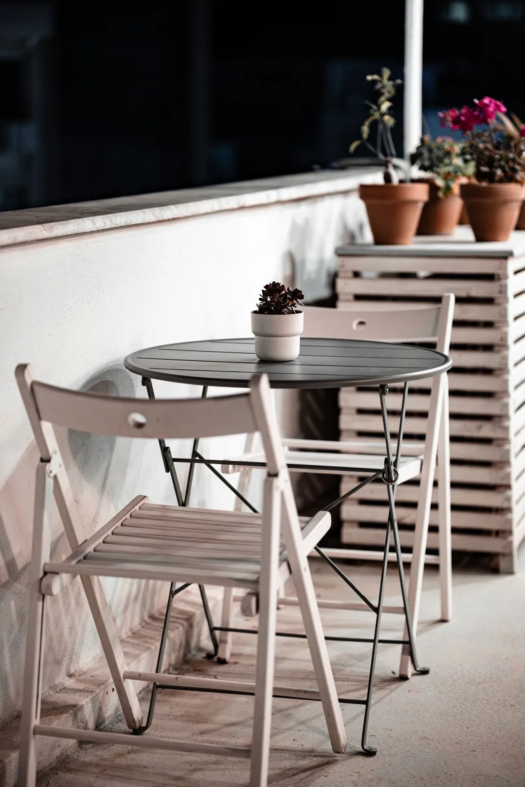 Folding chairs and a small table on a balcony