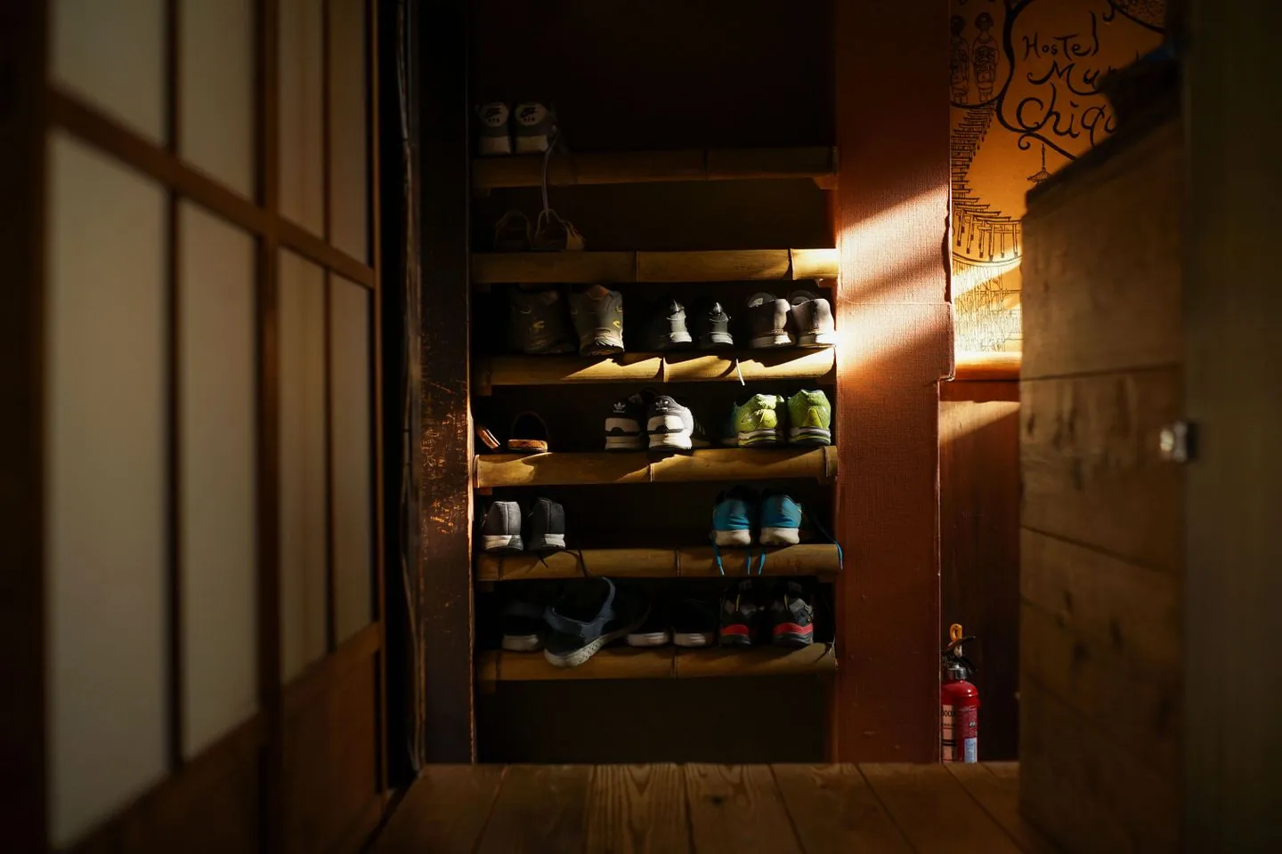Shoes arranged on a bamboo rack by an entrance