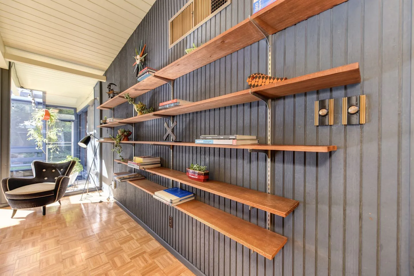 Reading chair beside open bookshelves and a window