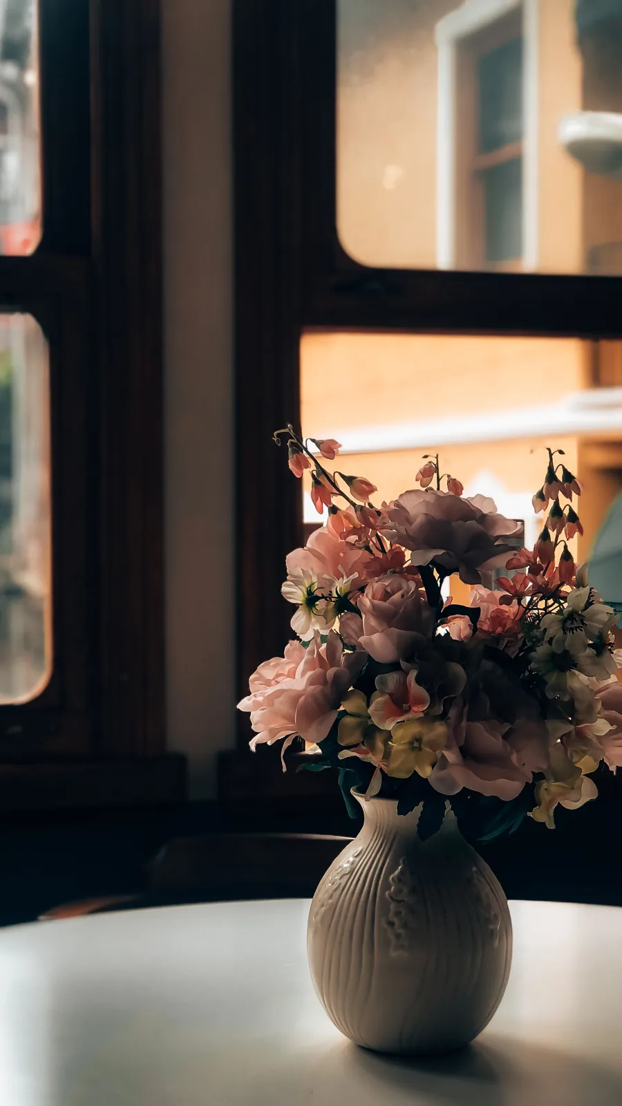 Flowers in a vase beside a window