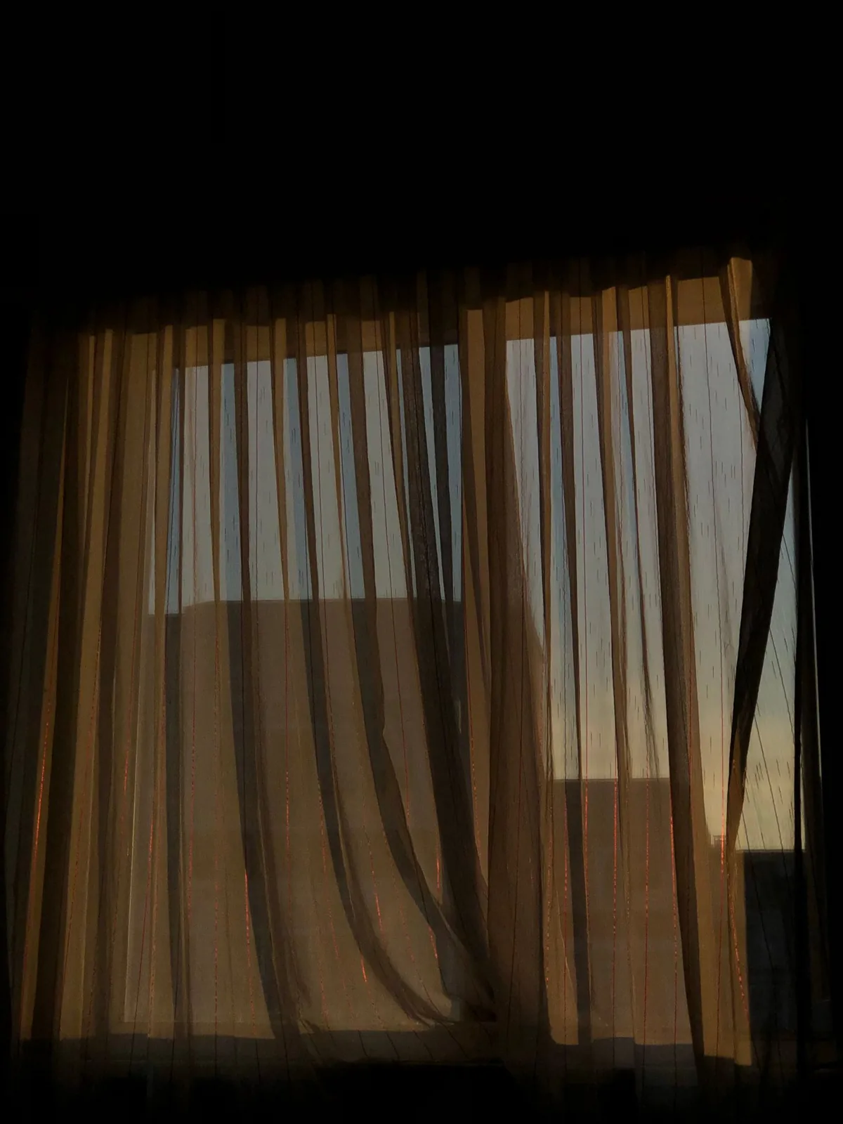 Sunlight filtering through a window curtain
