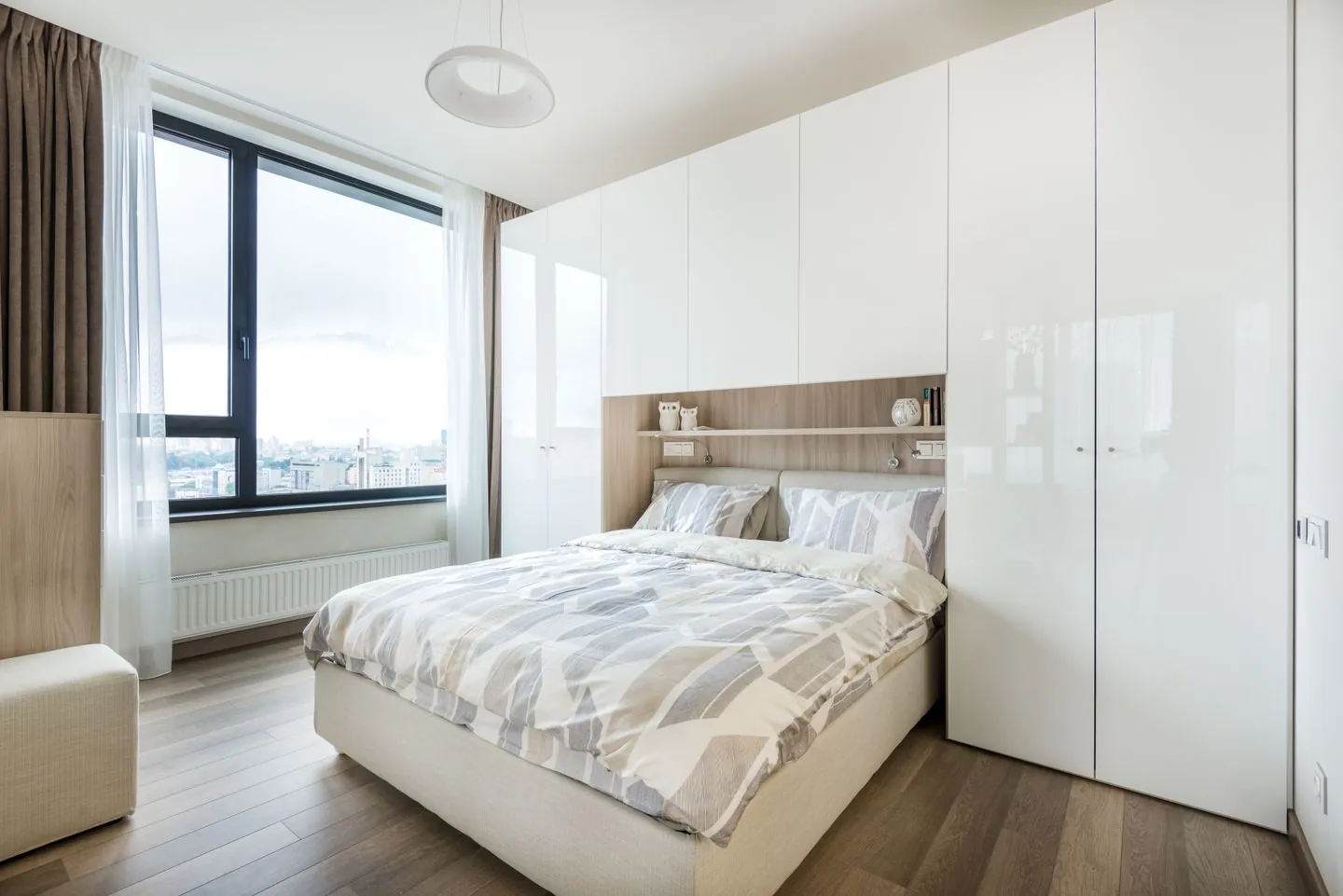 Bed tucked between built-in bedroom cupboards