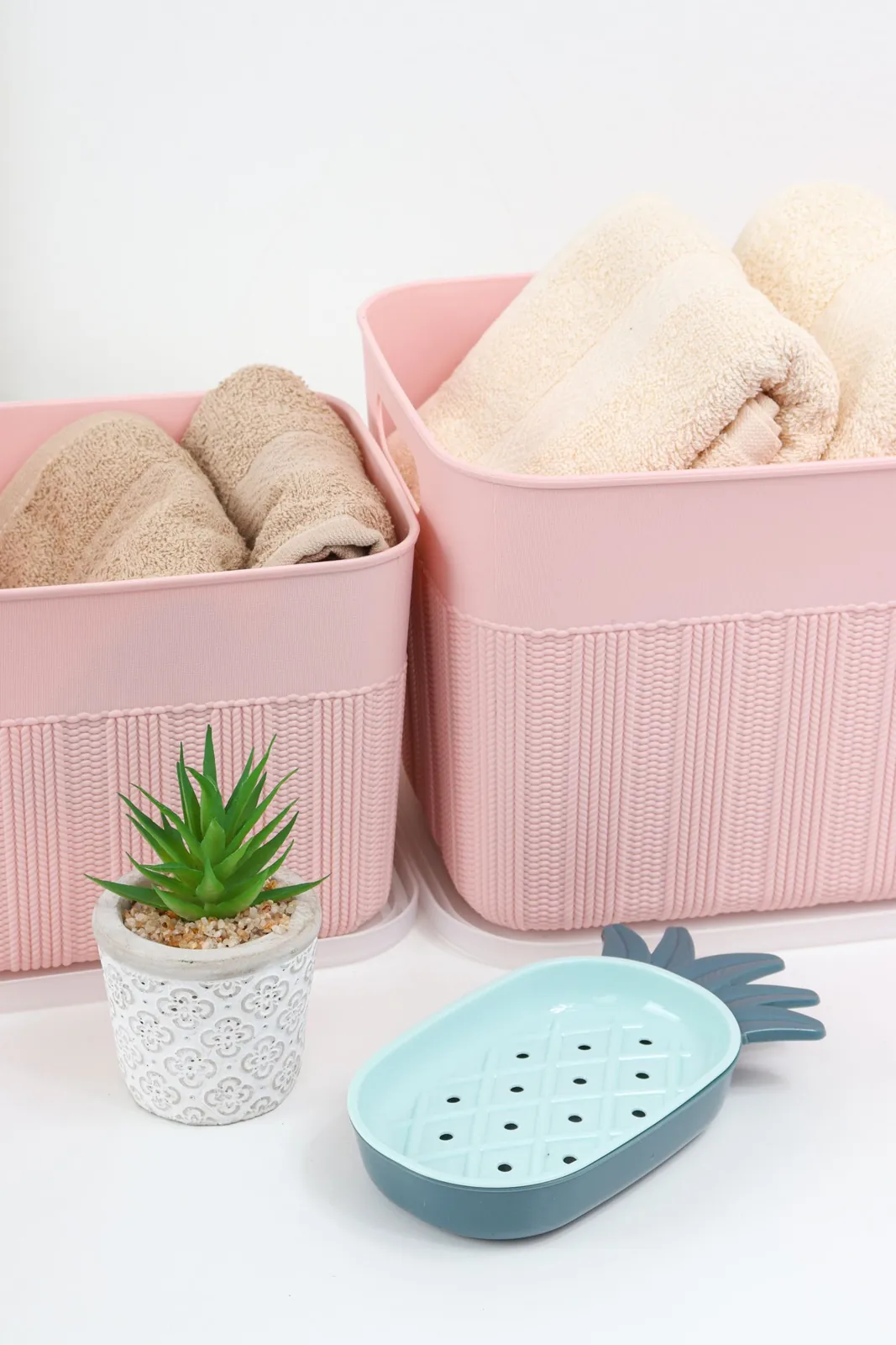 Folded towels and toiletries in small storage baskets