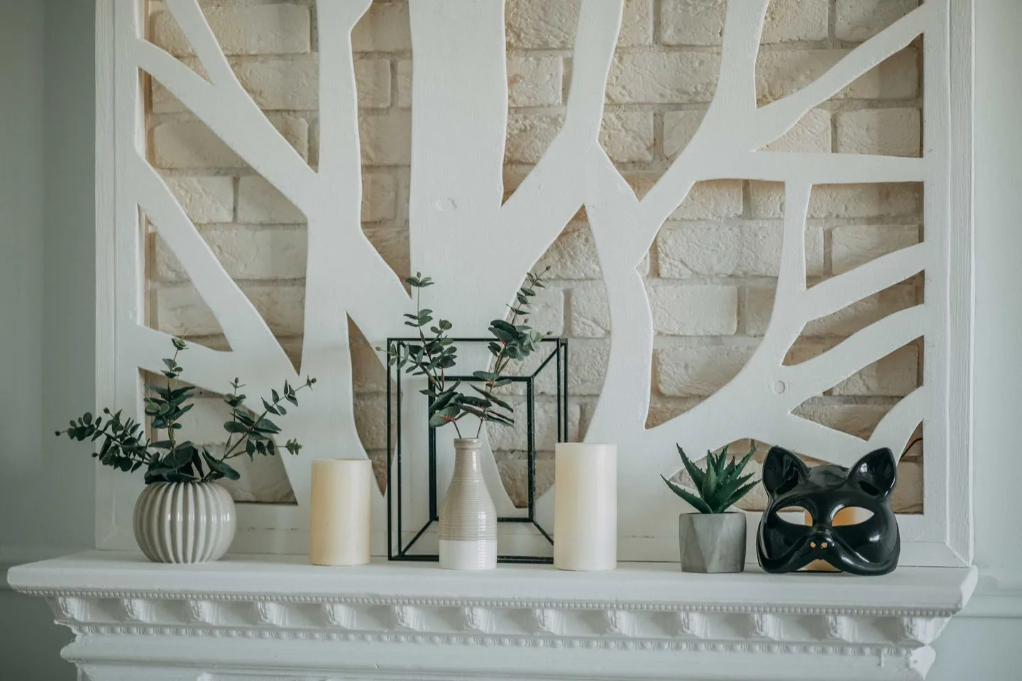 Vases, candles and a decorative object on a mantel
