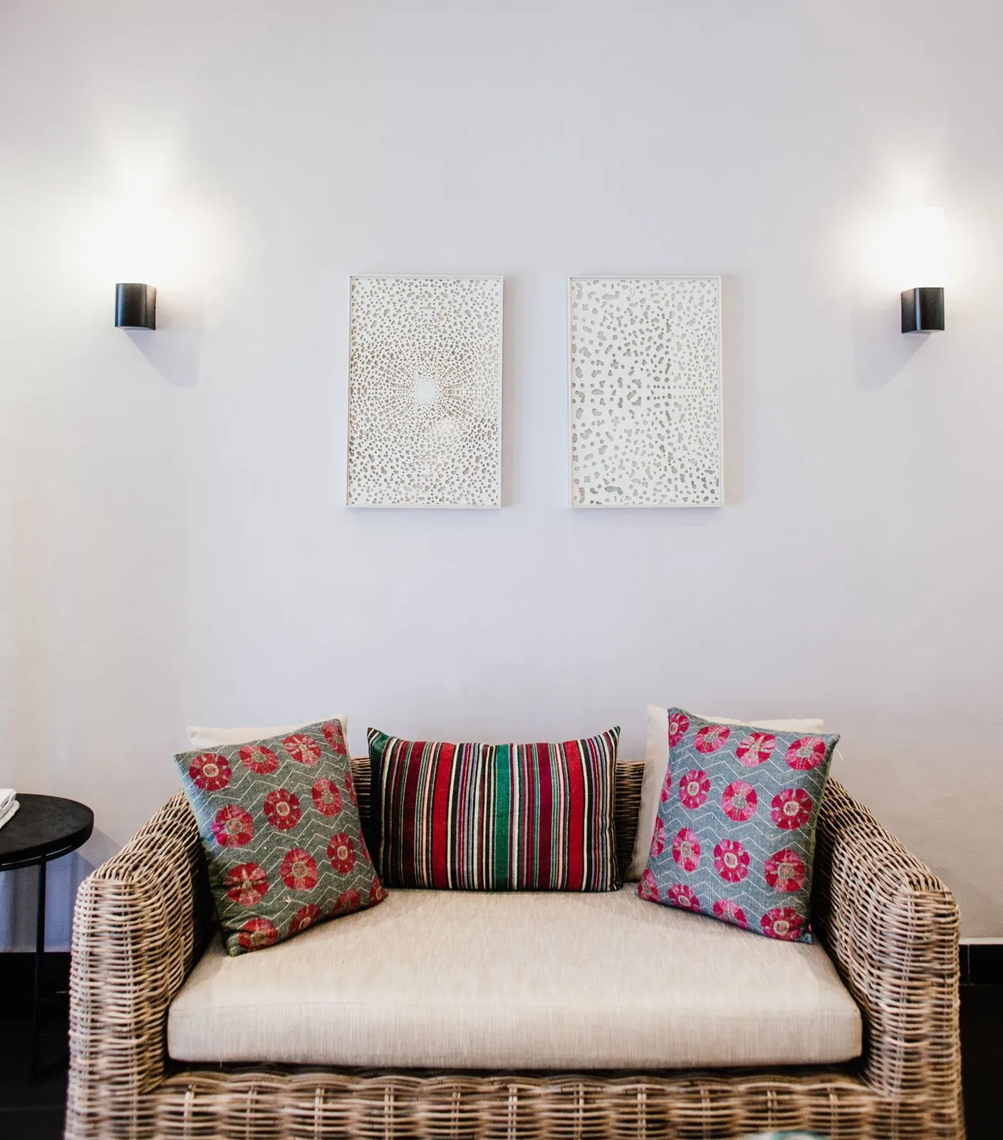 Patterned cushions and a woven seat in a pale room