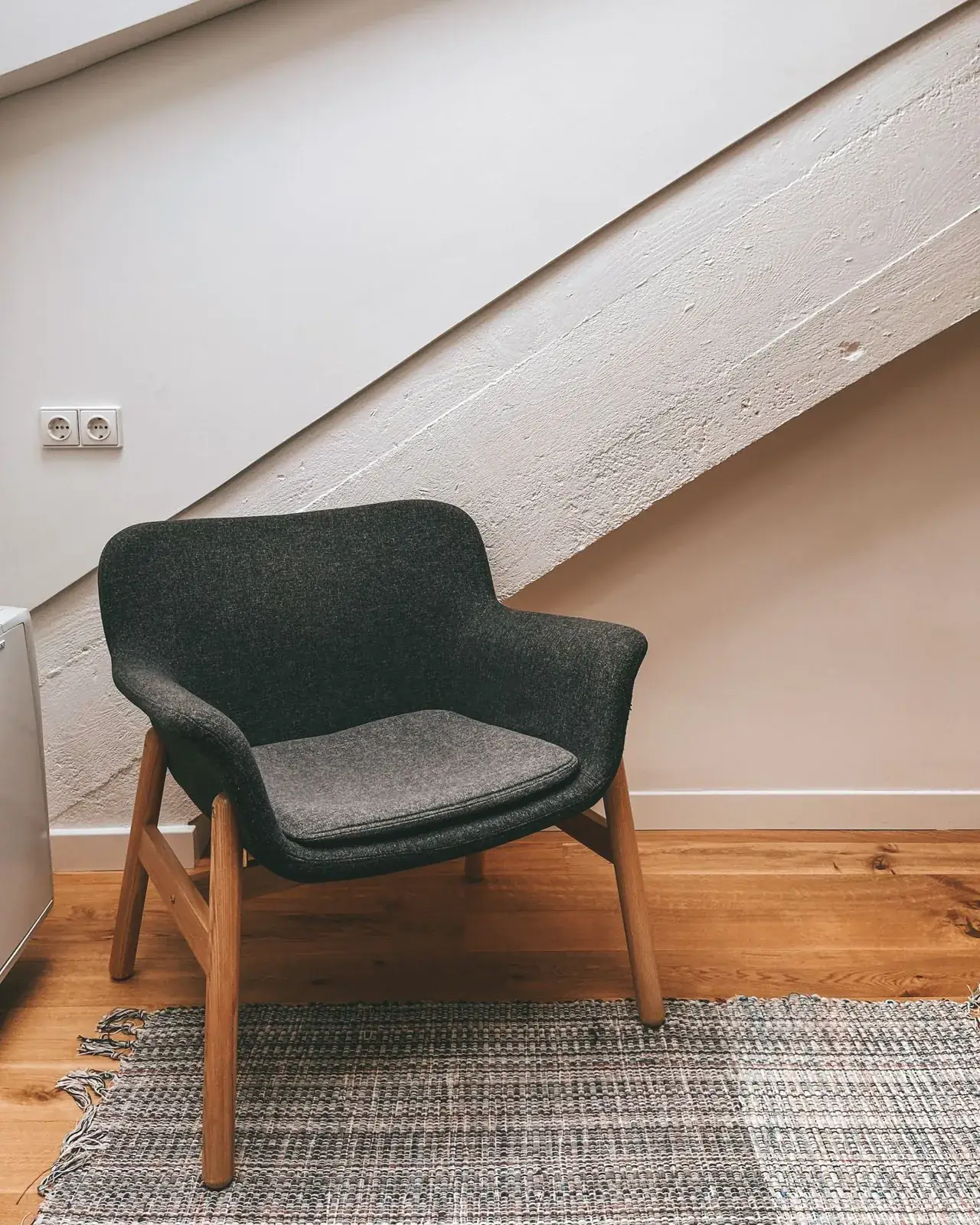 Green chair tucked beneath a sloping ceiling