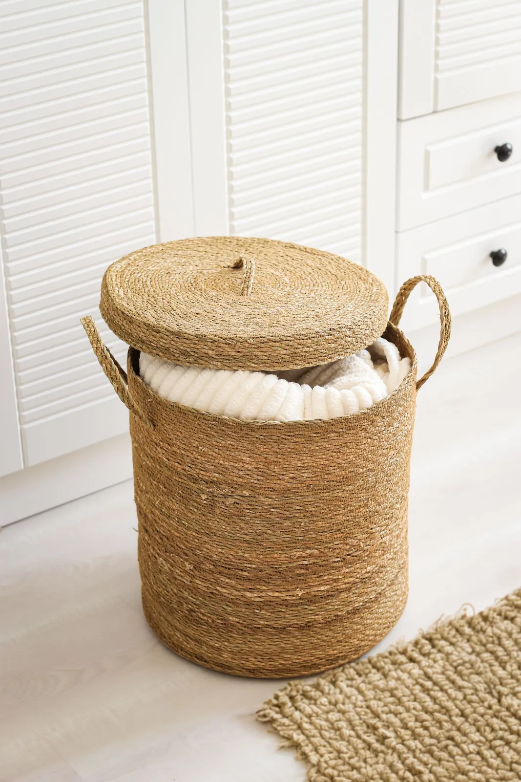 Lidded woven basket with a folded blanket